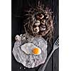 Quail eggs in the nest and a fried egg on a wooden board