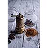 Vintage still life with brass pepper mill standing on the wooden background