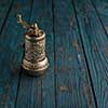 Vintage still life with brass pepper mill standing on the wooden background