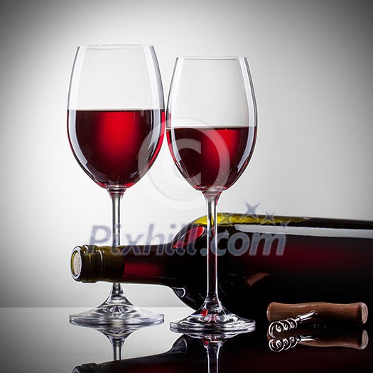 Wine in glasses and bottle on white