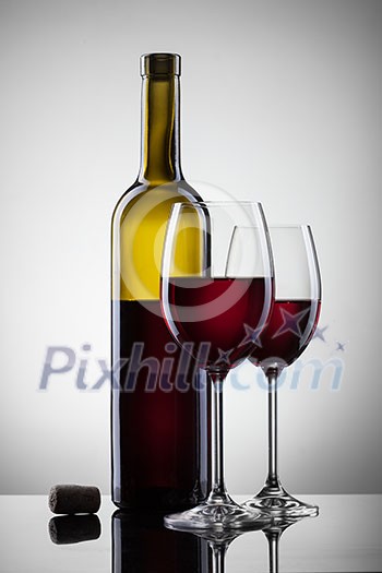 Wine in glasses and bottle on white