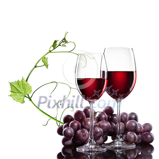 Red wine in glasses with grape and rod isolated on white