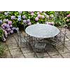 table and chairs in garden with color hydrangea flowers