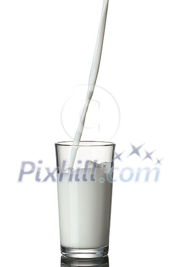 Milk pouring into the glass isolated on white Milk pouring into the glass isolated on white