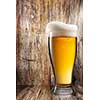 Glass of beer on wooden background