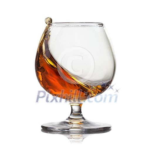 Splash of cognac in glass isolated on white background Splash of cognac in glass isolated on white background