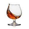 Splash of cognac in glass isolated on white background