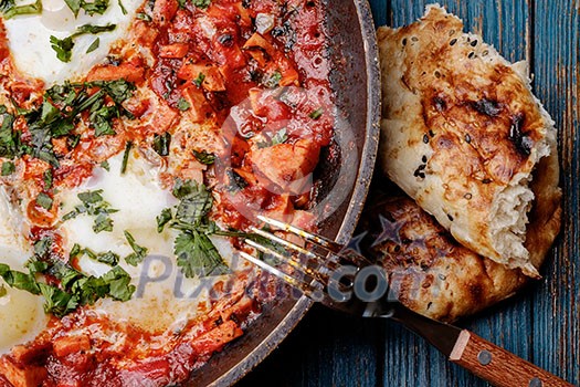 Fried eggs in a frying pan with tomatoes, sausage and greens. Fried eggs in a frying pan with tomatoes, sausage and greens.
