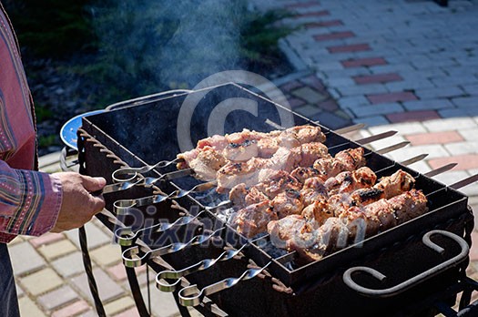 Preparation of shish kebabs outdoors. Lunch in a country house. Picnic in weekend. Preparation of shish kebabs outdoors. Lunch in a country house. Picnic in weekend.