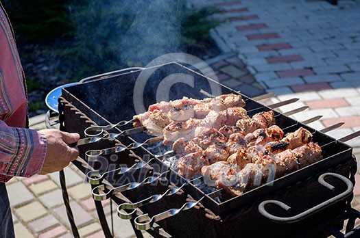 Preparation of shish kebabs outdoors. Lunch in a country house. Picnic in weekend.