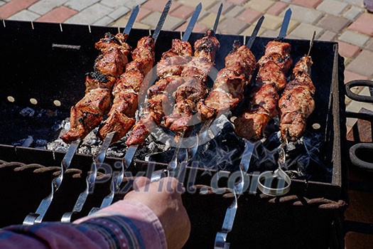 Preparation of shish kebabs outdoors. Lunch in a country house. Picnic in weekend. Barbecues on the grill.