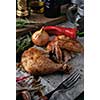 Roasted chicken leg and wing with spices and herbs on a wooden table. Tasty food. Rustic style.
