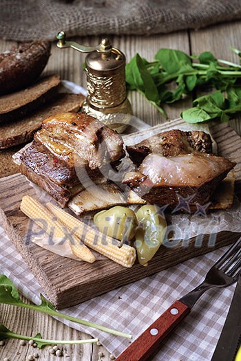 Baked spare ribs with herbs and spices. Wooden background. Rustic style.