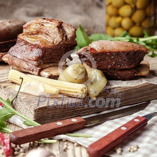 Baked spare ribs with herbs and spices. Wooden background. Rustic style.