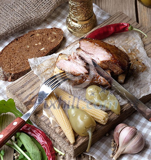 Baked spare ribs with herbs and spices. Wooden background. Rustic style.