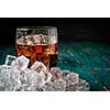 Glass of cola with ice on a wooden table. Copyspace on the right.