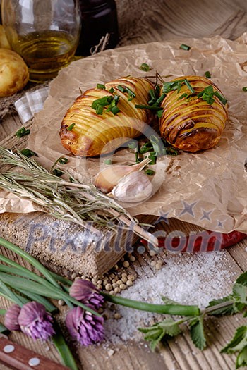 Sliced baked potatoes over wooden background. Rustic style. Sliced baked potatoes over wooden background. Rustic style.