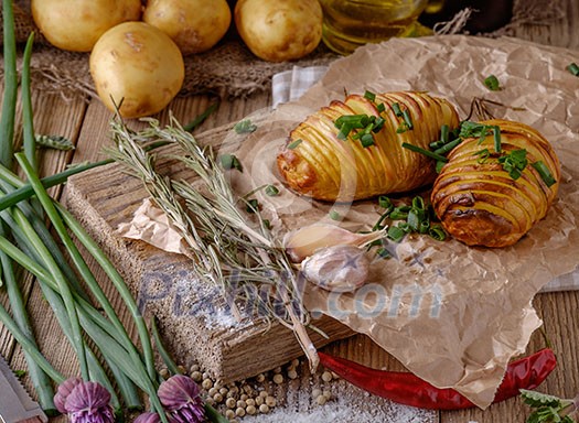 Sliced baked potatoes over wooden background. Rustic style. Sliced baked potatoes over wooden background. Rustic style.