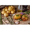 Sliced baked potatoes over wooden background. Rustic style.