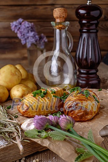 Sliced baked potatoes over wooden background. Rustic style.