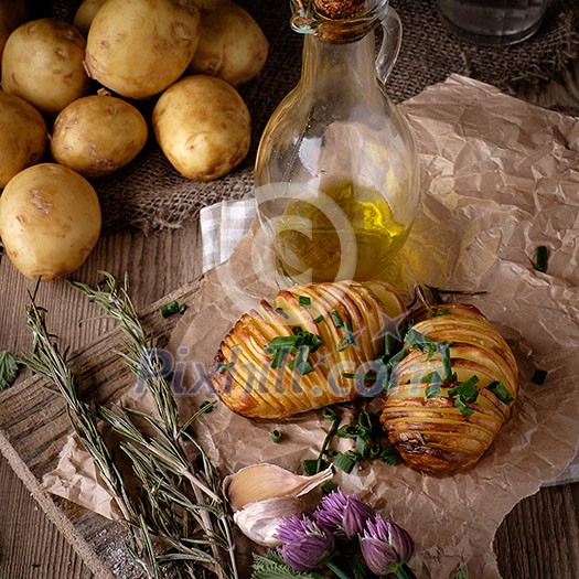 Sliced baked potatoes over wooden background. Rustic style.