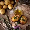 Sliced baked potatoes over wooden background. Rustic style.