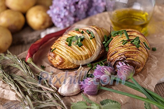 Sliced baked potatoes over wooden background. Rustic style.