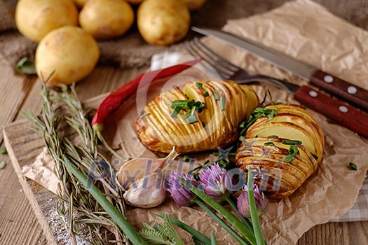 Sliced baked potatoes over wooden background. Rustic style.