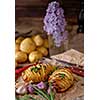 Sliced baked potatoes over wooden background. Rustic style.