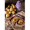 Sliced baked potatoes over wooden background. Rustic style.