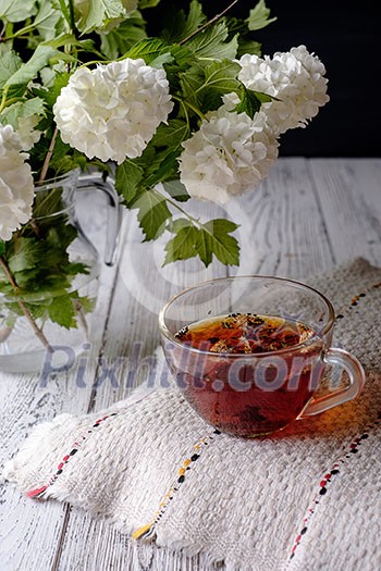 Cup of flower tea on a wooden table. Rustic style.