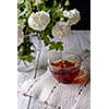 Cup of flower tea on a wooden table. Rustic style.