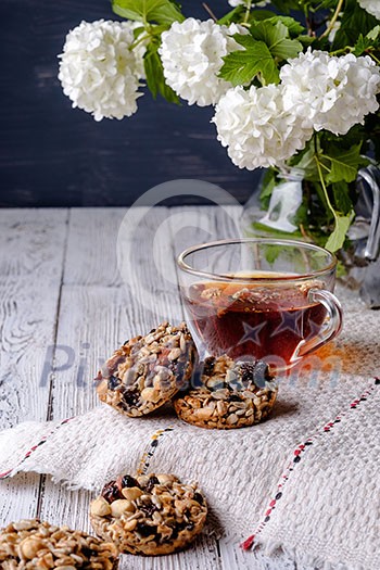 Cup of tea and cookies made of nuts and raisins. Kozinaki.