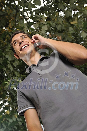 young happy  casual man talking on cellphone and writing sms message