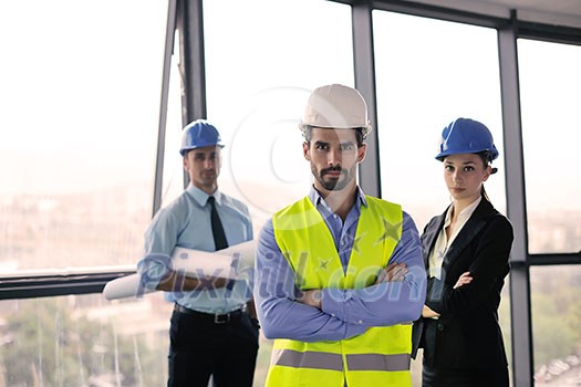 business people group on meeting and presentation in bright modern office with construction engineer architect and worker looking building model and blueprint plans business people group on meeting and presentation in bright modern office with construction engineer architect and worker looking building model and blueprint plans