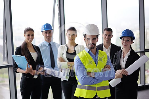 business people group on meeting and presentation in bright modern office with construction engineer architect and worker looking building model and blueprint plans business people group on meeting and presentation in bright modern office with construction engineer architect and worker looking building model and blueprint plans