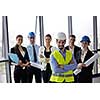 business people group on meeting and presentation  in bright modern office with construction engineer architect and worker looking building model and blueprint  plans