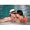 happy young couple relax and take fresh drink at summer vacation on swimmin pool