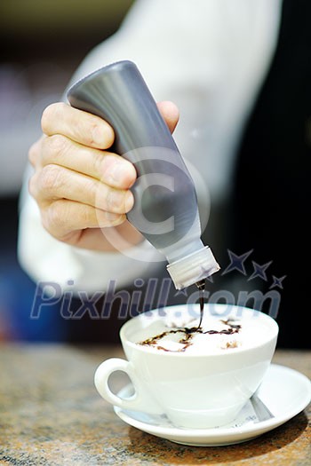 Barista prepares cappuccino in his coffee shop