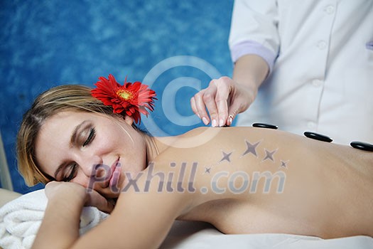 Beautiful young woman in spaand wellness. Face back and stone massage Beautiful young woman in spaand wellness. Face back and stone massage