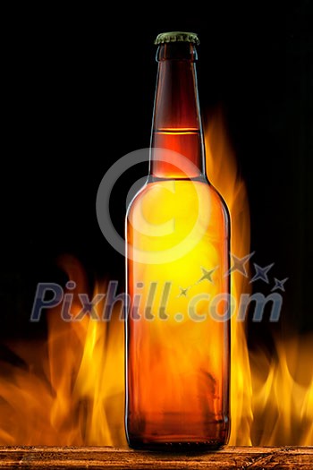 Beer bottle in fire on black Beer bottle in fire on black
