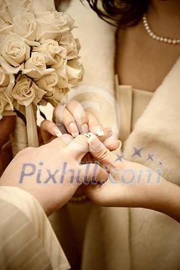puttting on a wedding ring. stylized photo