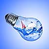 Energy concept. Light bulb with water and yacht inside isolated on white