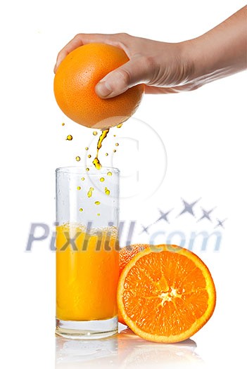 squeezing orange juice pouring into glass isolated on white