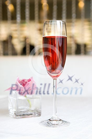 red alcohol cocktail in glass with orchid