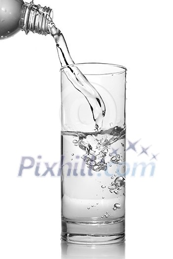 water pouring into glass from bottle isolated on white water pouring into glass from bottle isolated on white