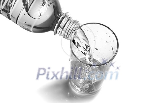 water pouring into glass from bottle isolated on white water pouring into glass from bottle isolated on white