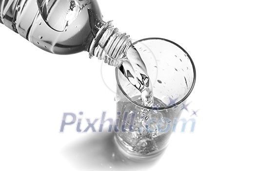 water pouring into glass from bottle isolated on white