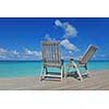 Two chairs beds in forest  on tropical beach with blue ocean in background