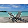 Two chairs beds in forest  on tropical beach with blue ocean in background